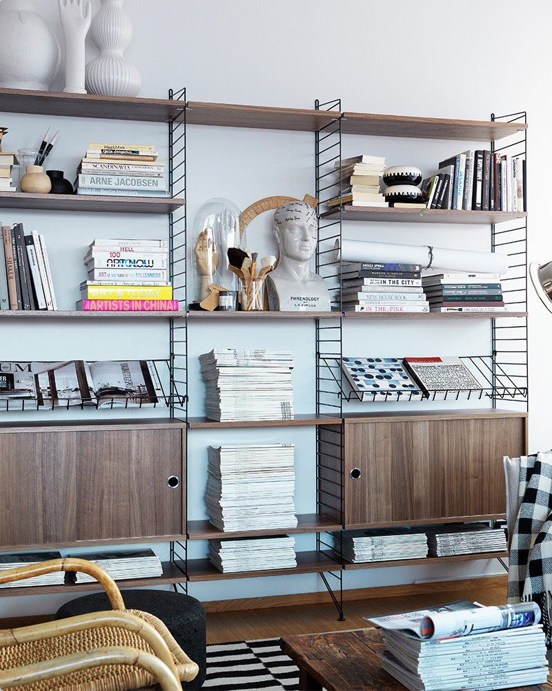 Étagère String murale garnie de livres, de magazines et d'objets déco